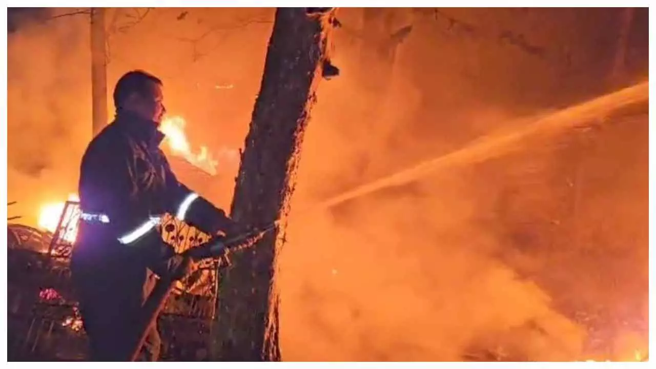 आग पर काबू करने का प्रयास करता दमकल कर्मी।