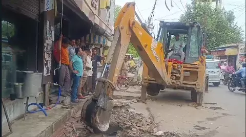 अवैध निर्माण तोड़ता बुलडोज़र।