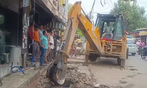 अवैध निर्माण तोड़ता बुलडोज़र।