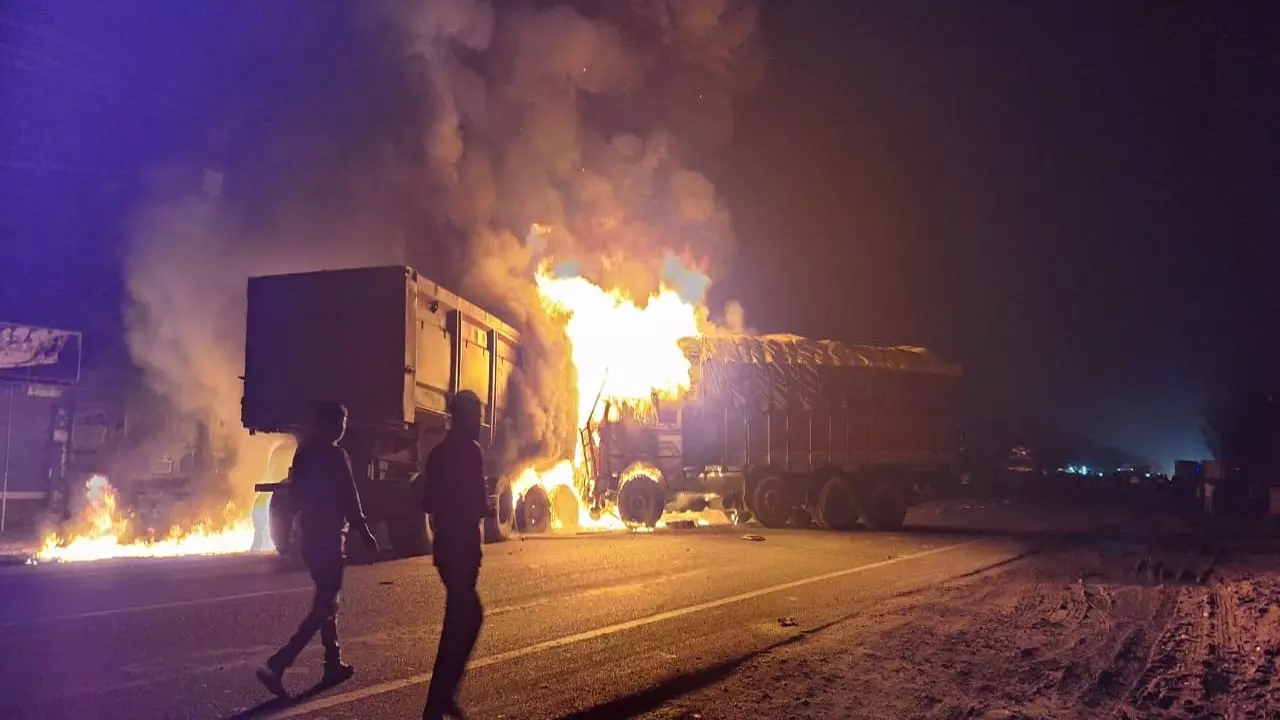 Fire sparked by cylinder rupture after two trucks collided on highway, with driver injured