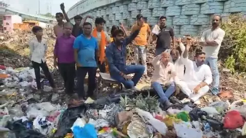 Lucknow News: कूड़े के ढेर पर डाली खटिया... MLA और मेयर के खिलाफ की नारेबाजी! प्रदर्शनकारी बोले- कूड़ाघर में तब्दील हो रहा पूरा इलाका