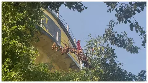 Woman climbing on water tank, Juti police and fire department team on occasion (
