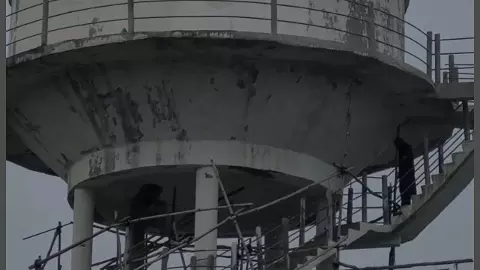 Mother-daughter climb water tank to stop construction on cemetery ground